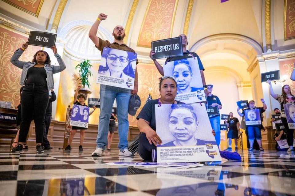 SEIU Local 1000 member Rose Guide Escobar, an EDD worker from Los Angeles, sits on the floor in the rotunda at the Capitol during a silent march Thursday.