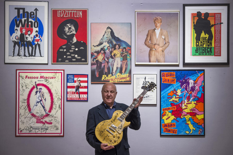 <p>Arts promoter Harvey Goldsmith holds a multi-signed Les Paul Gold Top guitar, including signatures from Bob Dylan and George Harrison, at Bonham's in central London, with some of his collection of entertainment memorabilia ahead of the forthcoming sale by the auction house. Picture date: Wednesday April 28, 2021.</p>
