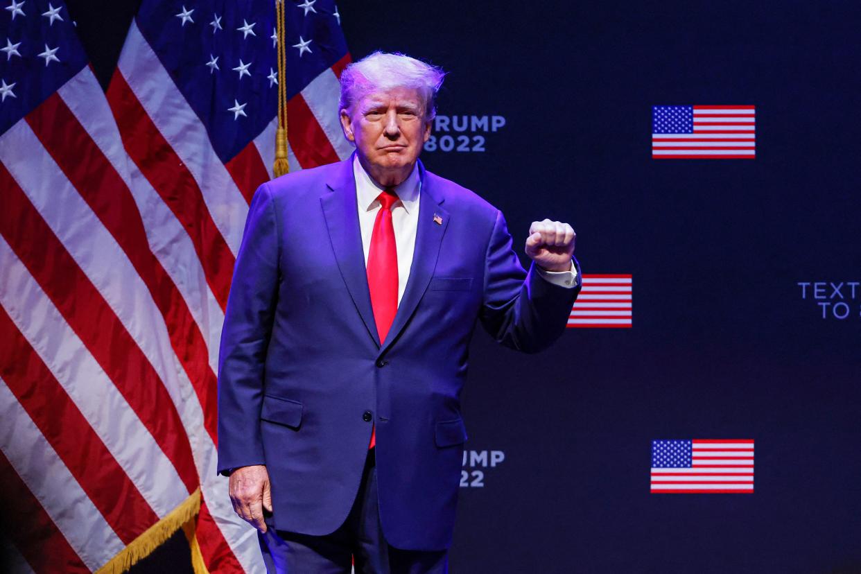 Former President Donald Trump raises his left fist as he arrives onstage.