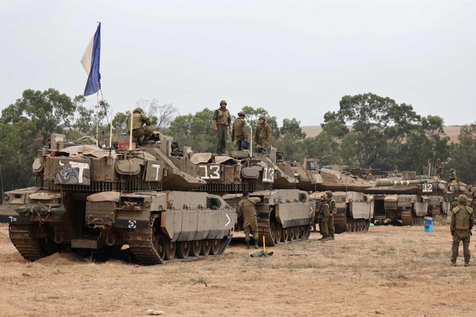 Israeli army soldiers are positioned with their Merkava tanks near the border with the Gaza Strip (AFP via Getty Images)