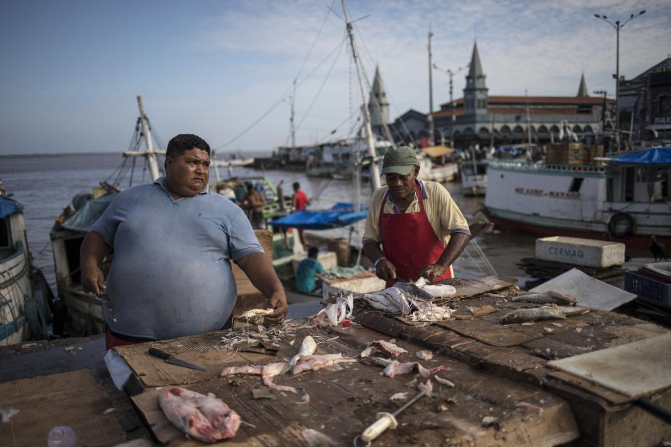 In this Sept. 7, 2019 photo, fish vendors work at their stands at the Ver-o-Peso riverside market in Belém, Brazil. Ver-O-Peso at the Guajara Bay riverside was originally a tax collection center for goods from the Amazon paid to the Portuguese crown. (AP Photo/Rodrigo Abd)