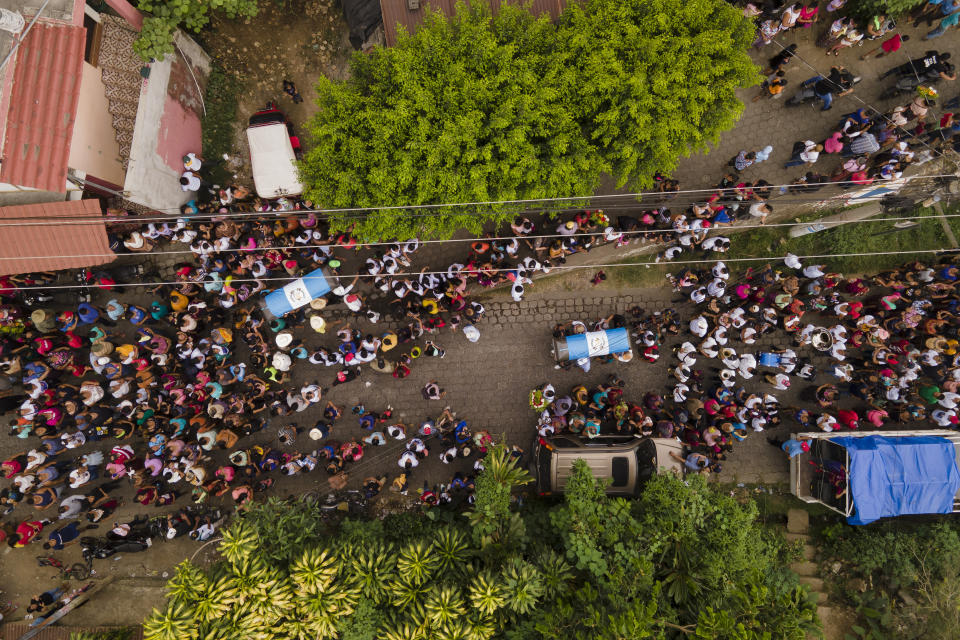 Los restos de Miguel Rojché, a la izquierda, y de su sobrino Francisco son trasladados desde su casa al cementerio, tras el velorio en Chicacao, Guatemala, el miércoles 12 de abril de 2023. Los dos hombres murieron en un incendio cuando estaba encerrados en un centro de detención de migrantes mexicano en Ciudad Juárez. (AP Foto/Moisés Castillo)