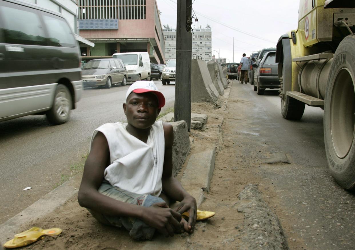 A limbless man begs for money on a traffic island in Luanda, Angola, on Nov. 3, 2005.