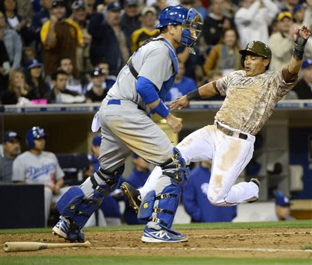 Mar 30, 2014; San Diego, CA, USA; San Diego Padres shortstop Everth Cabrera (2) scores ahead of a play by Los Angeles Dodgers catcher A.J. Ellis (17) in the eighth inning on the opening day baseball game at Petco Park. Christopher Hanewinckel-USA TODAY Sports