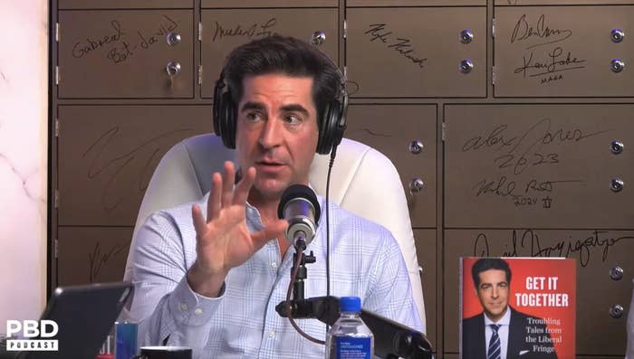 Man gesturing while recording a podcast, with plaques and a book with his face on the cover in the background