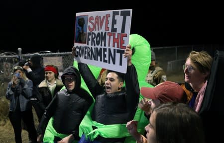 People carry signs outside a gate to Area 51 as an influx of tourists responding to a call to 'storm' Area 51, a secretive U.S. military base believed by UFO enthusiasts to hold government secrets about extra-terrestrials, is expected in Rachel, Nevada