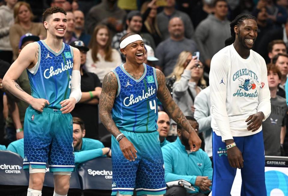 Charlotte Hornets guards LaMelo Ball, left, Isaiah Thomas, center, center Montrezl Harrell, right, enjoy their teammates efforts against the Utah Jazz during late second half action at Spectrum Center in Charlotte, NC on Friday, March 25, 2022. The Hornets defeated the Utah Jazz 107-101.