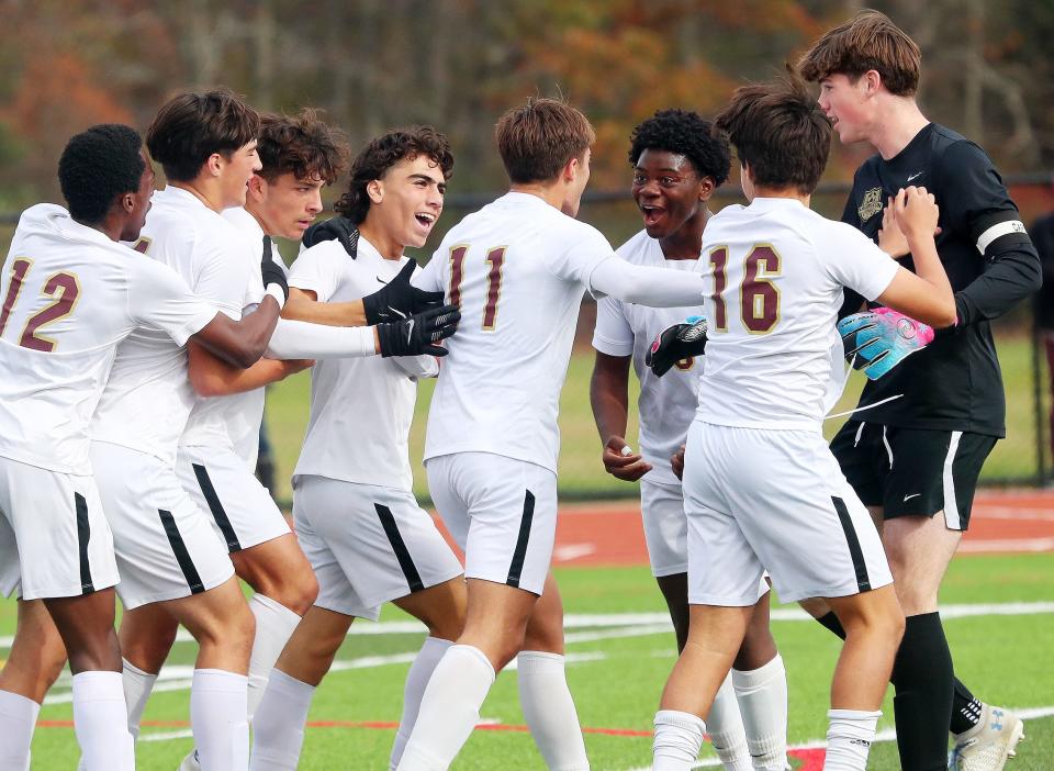 Arlington's Robert Sherman (11) is mobbed by teammates after scoring a first-half goal against Kingston during the boys Class AAA soccer regional final at FDR-Hyde Park Nov. 4, 2023.