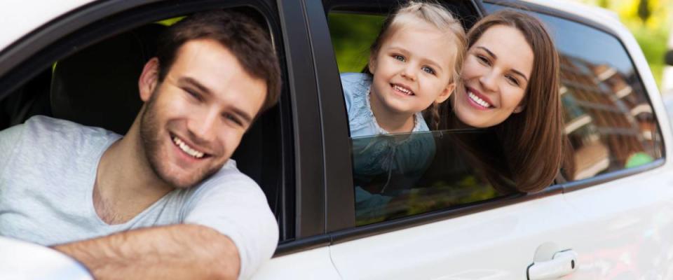 Family sitting in the car looking out windows