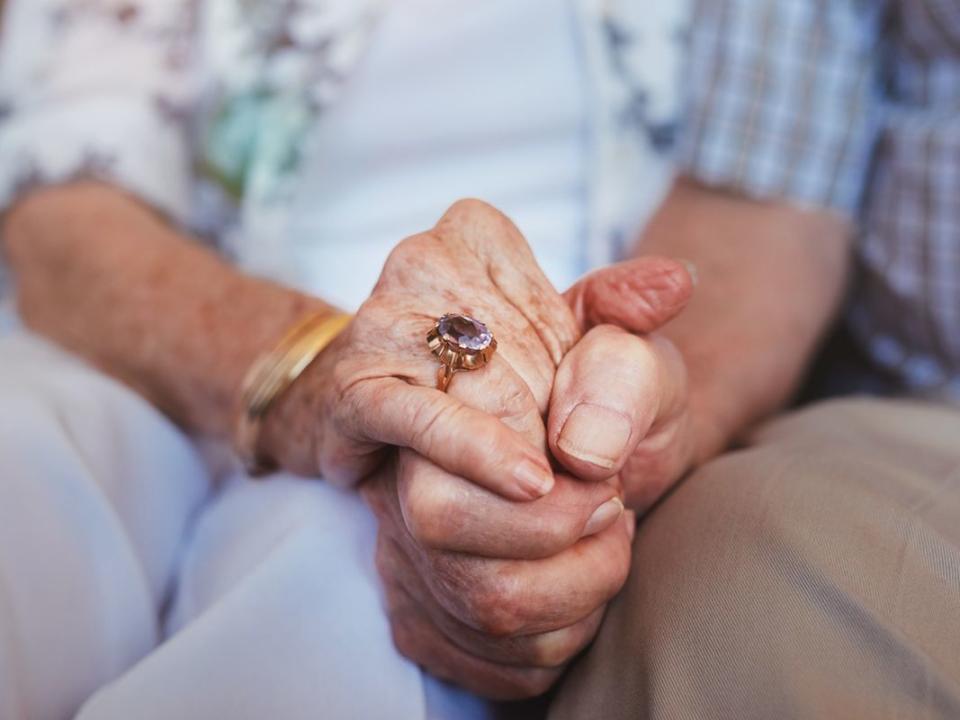 Elderly couple holding hands