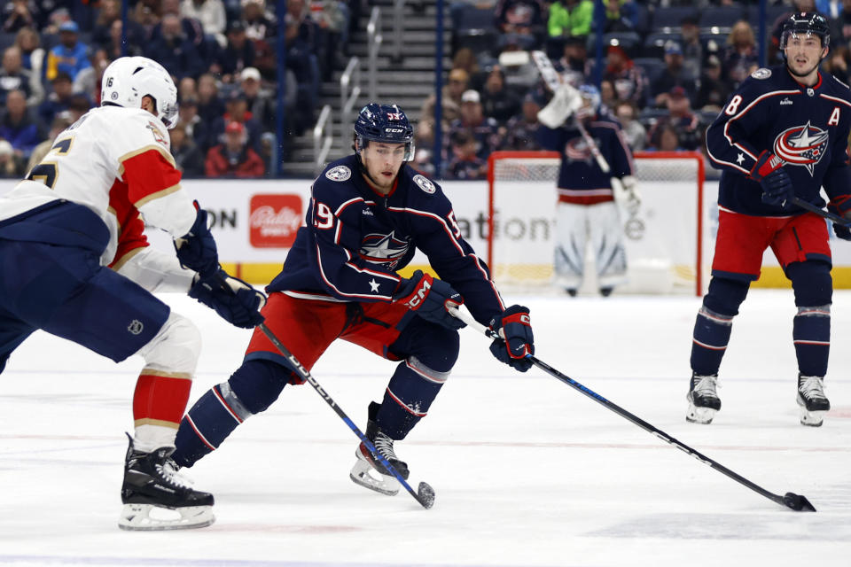 Columbus Blue Jackets forward Yegor Chinakhov, right, controls the puck in front of Florida Panthers forward Aleksander Barkov during the second period of an NHL hockey game in Columbus, Ohio, Sunday, Dec. 10, 2023. (AP Photo/Paul Vernon)