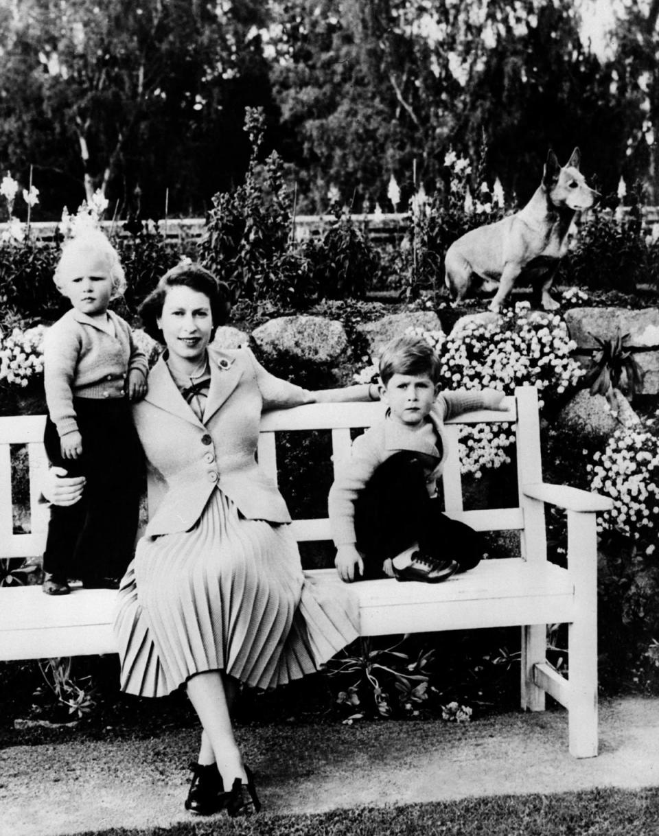 Queen Elizabeth II, her two children Charles (R) and Ann and a corgi posing in Balmoral (-/AFP via Getty Images)