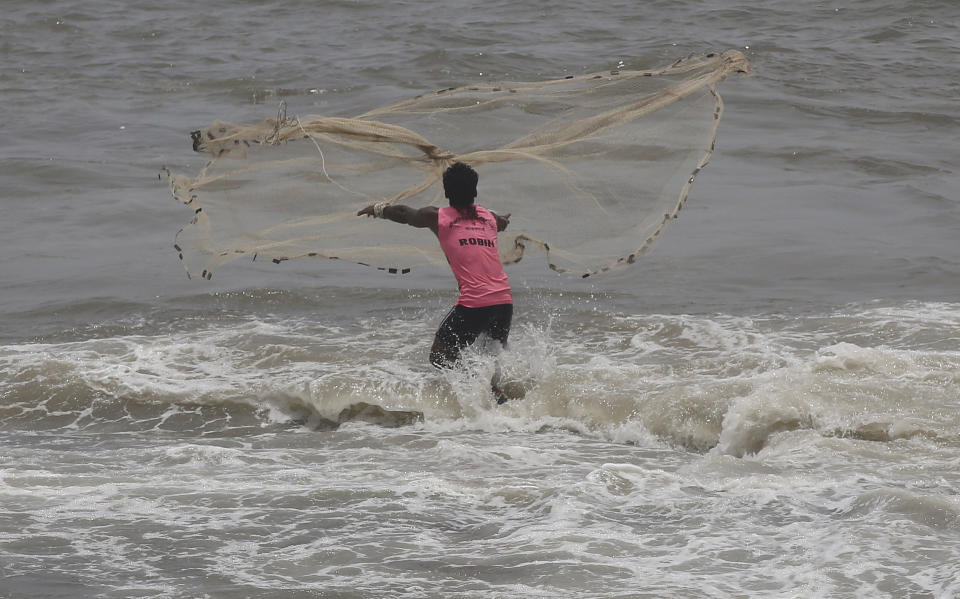 An Indian fisherman cast his net during high tide at Arabian Sea in Mumbai, India, June 19, 2019.(AP Photo/Rafiq Maqbool)