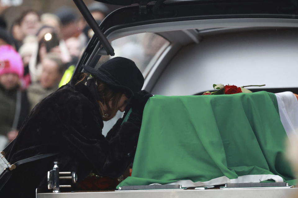 Victoria Mary Clarke, wife of Shane MacGowan, pays respects to his coffin as it arrives for the funeral of Shane MacGowan, at Saint Mary's of the Rosary Church, Nenagh, Ireland, Friday, Dec. 8, 2023. MacGowan, the singer-songwriter and frontman of The Pogues, best known for their ballad “Fairytale of New York,” died on Thursday, Nov. 30, 2023. He was 65. (Niall Carson/PA via AP)