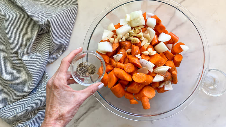 adding pepper to carrots