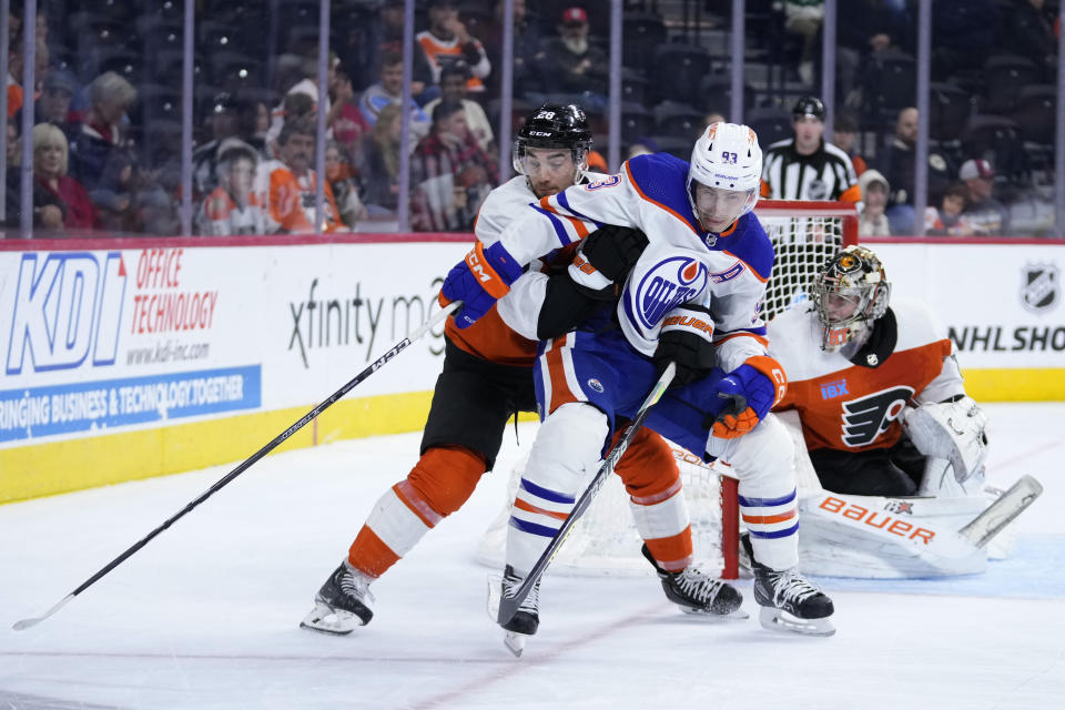 Philadelphia Flyers' Sean Walker, left, and Edmonton Oilers' Ryan Nugent-Hopkins collide during the third period of an NHL hockey game, Thursday, Oct. 19, 2023, in Philadelphia. (AP Photo/Matt Slocum)