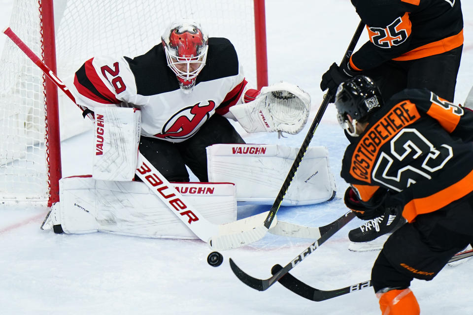 New Jersey Devils' Mackenzie Blackwood, left, blocks a shot by Philadelphia Flyers' Shayne Gostisbehere during the third period of an NHL hockey game, Saturday, May 1, 2021, in Philadelphia. (AP Photo/Matt Slocum)