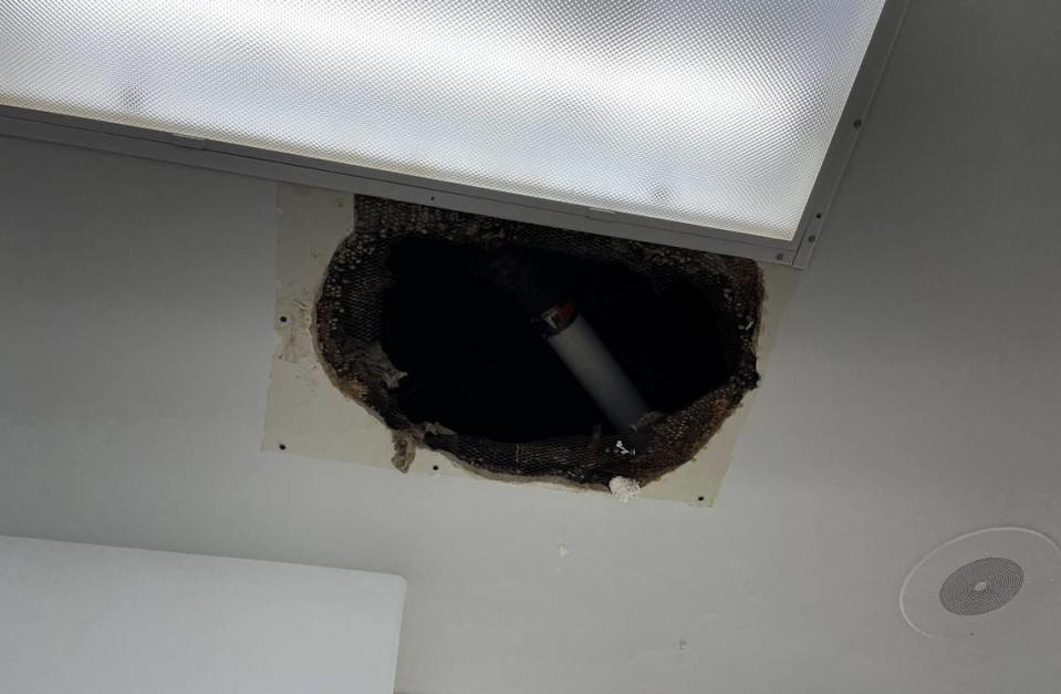 A hole in the ceiling at Culbreth Middle School in Carrboro provides access to a water pipe for repairs.