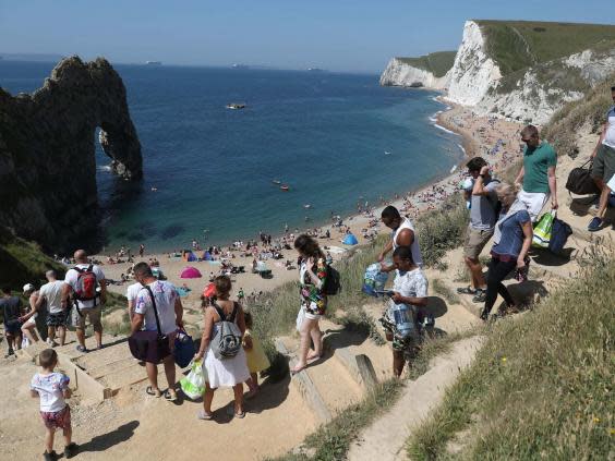 People make their way down to the sea Durdle Door as the public have been allowed to go to beaches (Andrew Matthews/PA Wire)