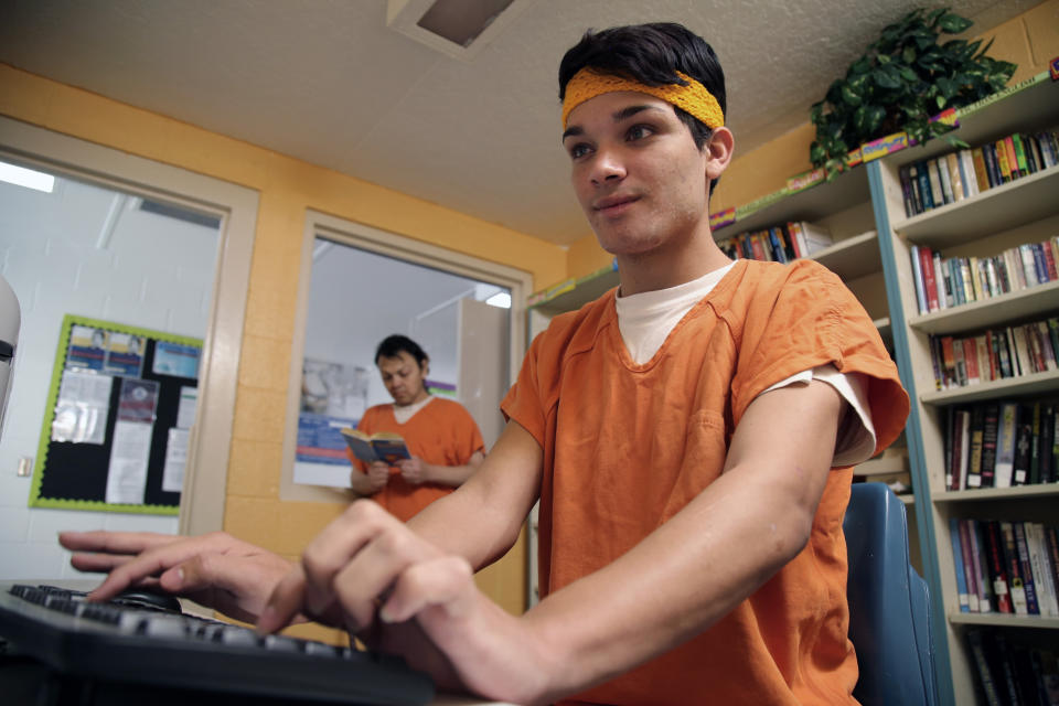 This June 6, 2019 image provided by U.S. Immigration and Customs Enforcement shows immigration detainees using the law library at a dedicated unit for transgender migrants in the Cibola County Correctional Center in Milan, N.M. (Ron Rogers/U.S. Immigration and Customs Enforcement via AP)