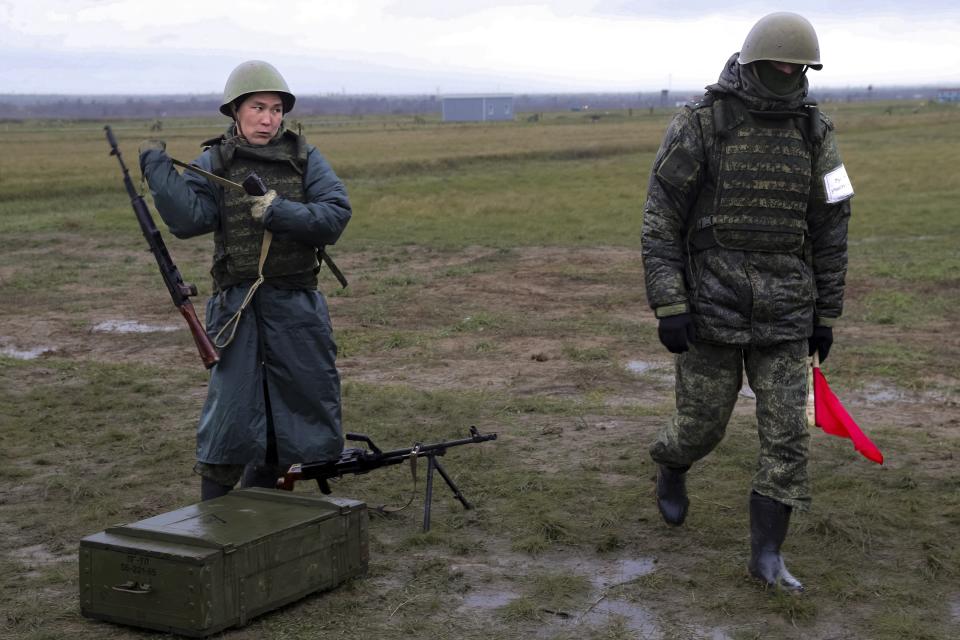 A recruit takes his weapons following an instructor during a military training at a firing range in Volgograd region, Russia, Thursday, Oct. 27, 2022. (AP Photo)