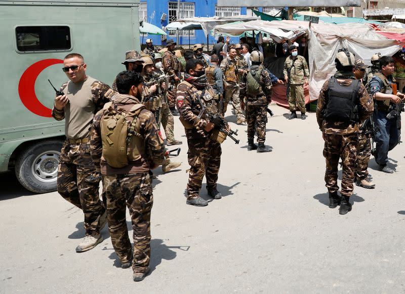 Afghan security forces stand guard outside a hospital which came under attack in Kabul