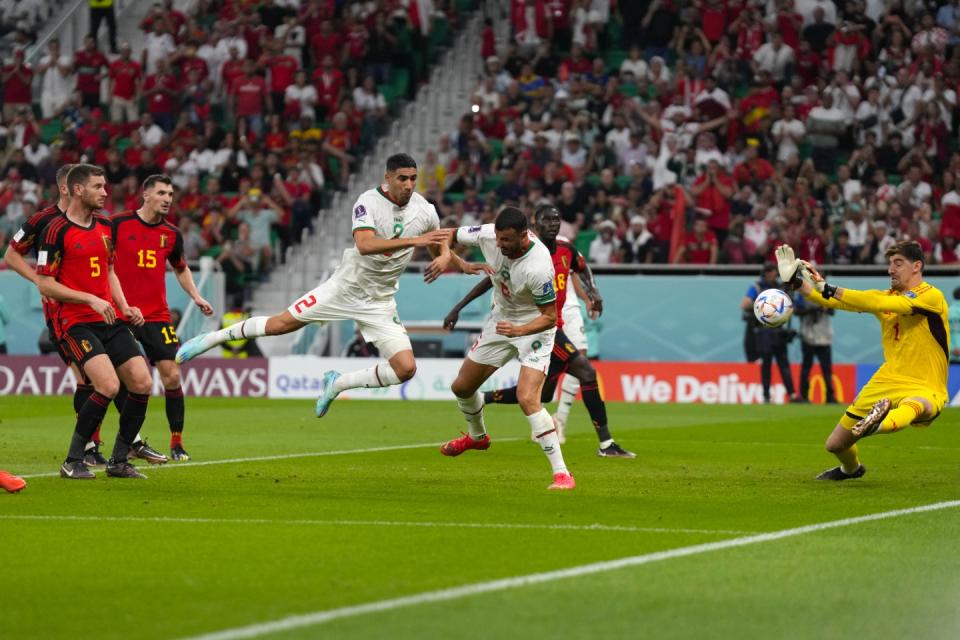 A ball goes past the Belgium's goalkeeper Thibaut Courtois, right, as Morocco's Romain Saiss, centre, and Morocco's Achraf Hakimi block his view from an offside position during the World Cup group F football match between Belgium and Morocco, at the Al Thumama Stadium in Doha, Qatar, Sunday, Nov. 27, 2022. (AP Photo/Alessandra Tarantino)