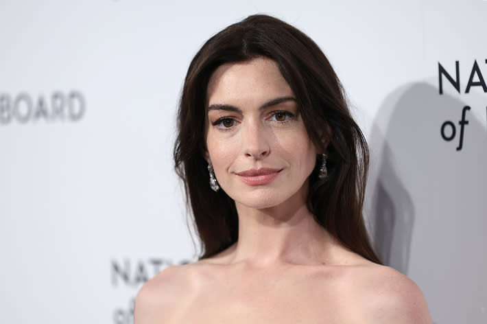 Woman in off-shoulder elegant attire with earrings at a formal event