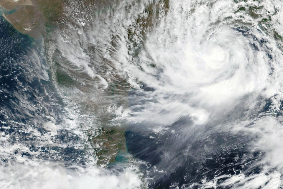 This Tuesday, May, 25, 2021, satellite image provided by NASA shows Cyclone Yaas approaching India's eastern coast. Tens of thousands of people are being evacuated from low-lying areas of two Indian states to escape the strong cyclone barreling toward the eastern coast. Yaas is expected to make landfall Wednesday in West Bengal and Odisha states. It comes amid a coronavirus surge, complicating India's efforts to deal with both. (NASA Worldview, Earth Observing System Data and Information System (EOSDIS) via AP)