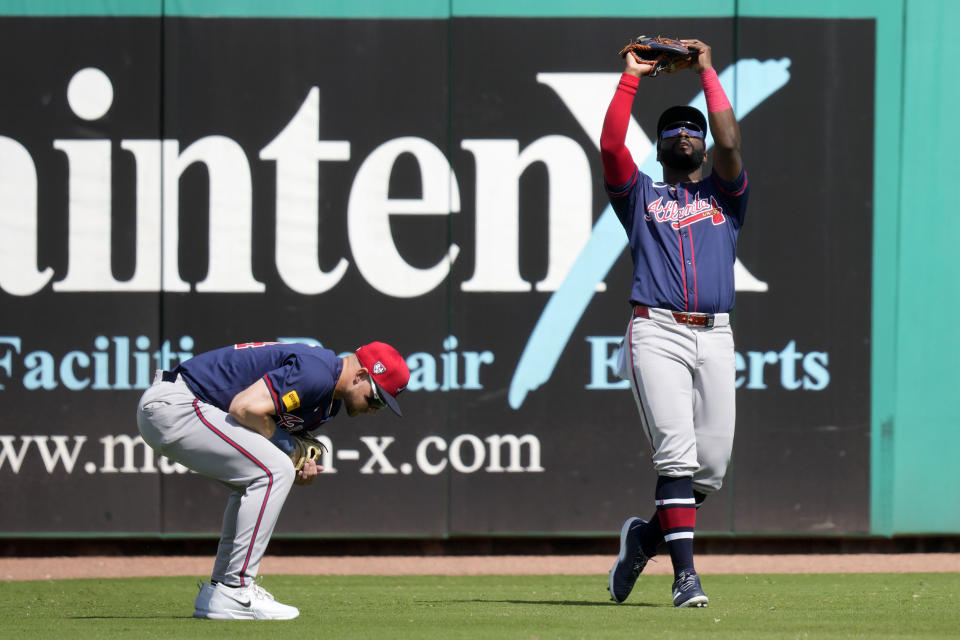 Atlanta Braves center fielder Michael Harris II catches a fly ball over left fielder Jarred Kelenic, left, during the second inning of a spring training baseball game Wednesday, Feb. 28, 2024, in Clearwater, Fla. (AP Photo/Charlie Neibergall)