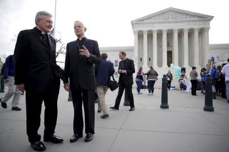 Bishop David Zubik (L) of Pittsburgh and Cardinal Donald Wuerl of Washington speak before before Zubik v. Burwell, an appeal brought by Christian groups demanding full exemption from the requirement to provide insurance covering contraception under the Affordable Care Act, is heard by the U.S. Supreme Court in Washington, March 23, 2016. REUTERS/Joshua Roberts