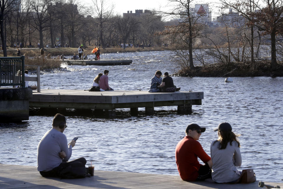 People sit on docks in the Charles River Esplanade park, in Boston, Sunday, Jan. 12, 2020, while enjoying unseasonably warm weather. Temperatures climbed into the low 70s in many places in the state Sunday. (AP Photo/Steven Senne)