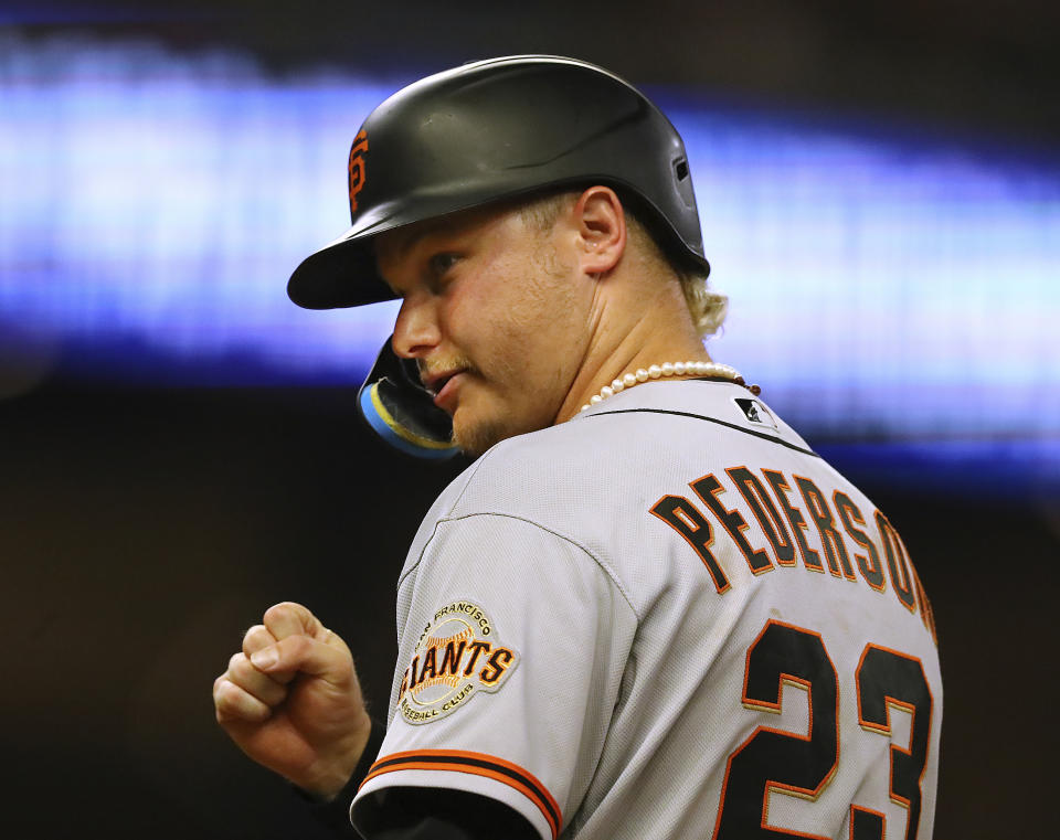 San Francisco Giants outfielder Joc Pederson, who had a solo homer in the game, pumps his fist while clowning around with the Braves from first base after an intentional base on balls during the ninth inning of of a baseball game on Tuesday, June 21, 2022, in Atlanta. (Curtis Compton Atlanta Journal-Constitution via AP)