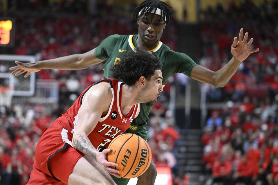 Texas Tech guard Pop Isaacs (2) drives to the basket against Baylor guard Ja'Kobe Walter during the first half of an NCAA college basketball game Saturday, March 9, 2024, in Lubbock, Texas. (AP Photo/Justin Rex)