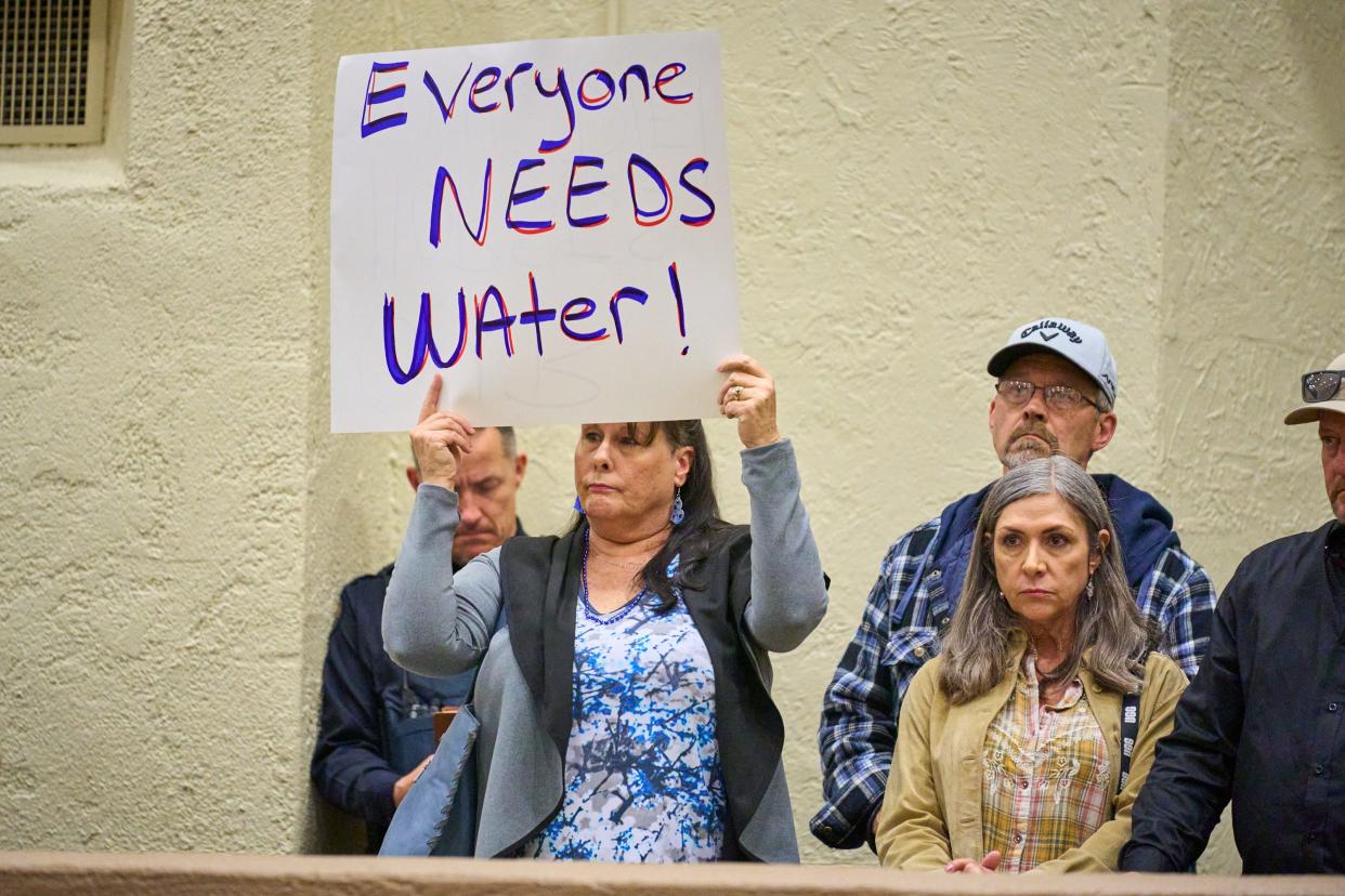 Lisa Nelson holds a sign in protest of her and other residents of the Rio Verde Foothills loosing their access to water after Scottsdale shutoff the standpipe at the start of the year, during a Scottsdale city council meeting at the Scottsdale Civic Center on Tuesday, Jan. 10, 2023.