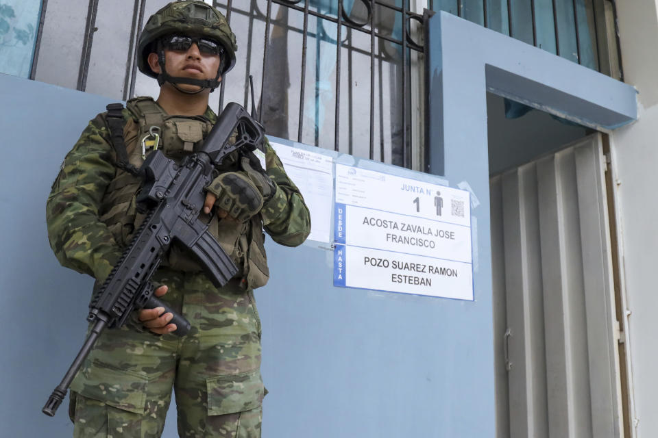 A soldier guars a pollen station during referendum proposed by President Daniel Noboa to endorse new security measures aimed at cracking down on criminal gangs fueling escalating violence, in Olon, Ecuador, Sunday, April 21, 2024. (AP Photo/Cesar Munoz)