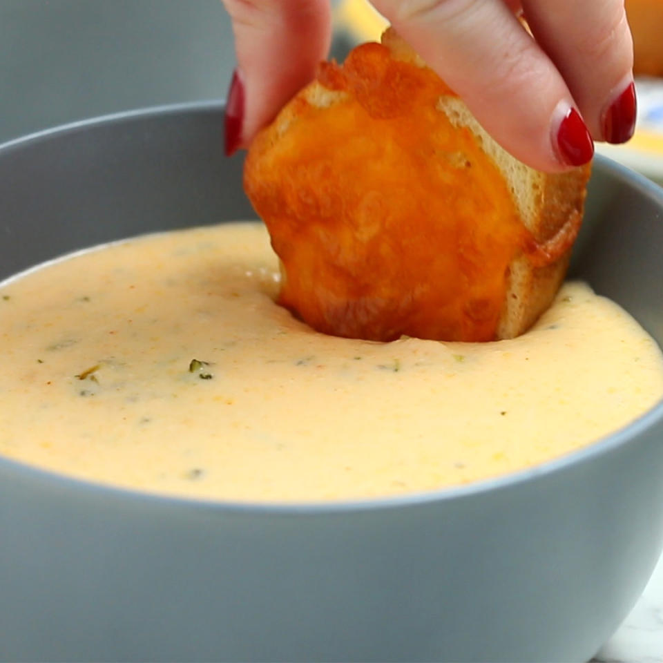 Person dipping bread into a bowl of soup