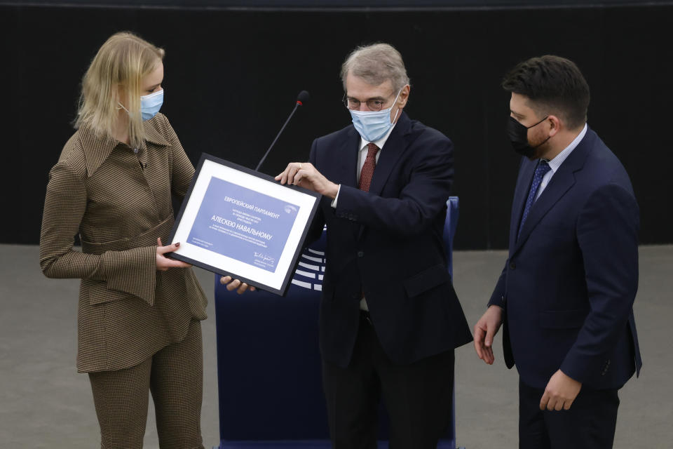 Daria Navalnaya, the daughter of jailed Russian opposition leader Alexei Navalny, gets the Sakharov Prize from European Parliament President David Sassoli as Russia's Leonid Volkov, Chief of staff for the 2018 presidential election fof Alexei Navalny's campaign, looks on, at the European Parliament in Strasbourg, eastern France, Wednesday, Dec.15, 2021. Daria Navalnaya received the Sakharov Prize for Freedom of Thought Award, the European Union top human rights prize, on behalf of her father. (AP Photo/Jean-Francois Badias)