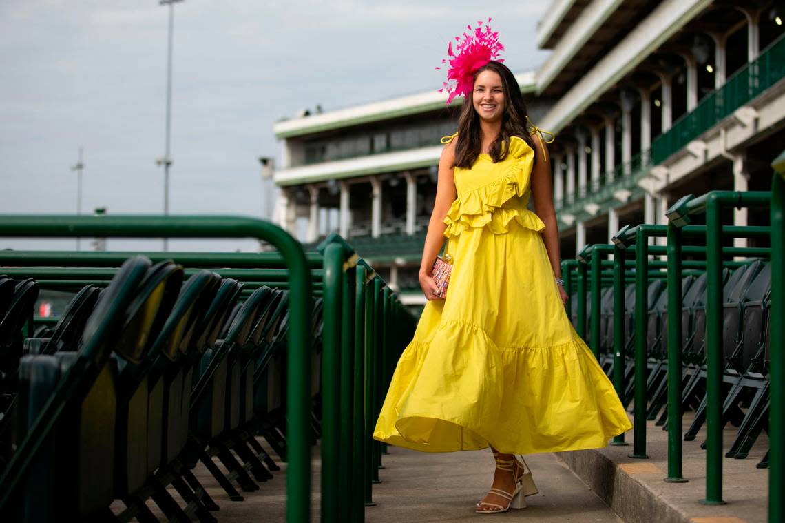 Elizabeth Montgomery pops in yellow at Churchill Downs in Louisville, Ky., Saturday, May 6, 2023. Her ankle leghth dress is from Daphne Taylor, prse from Revolve and the bright pink fascinator from Hat Girls. Amy Wallot