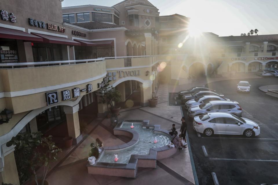 A few visitors linger near the shops and restaurants in San Gabriel Square.