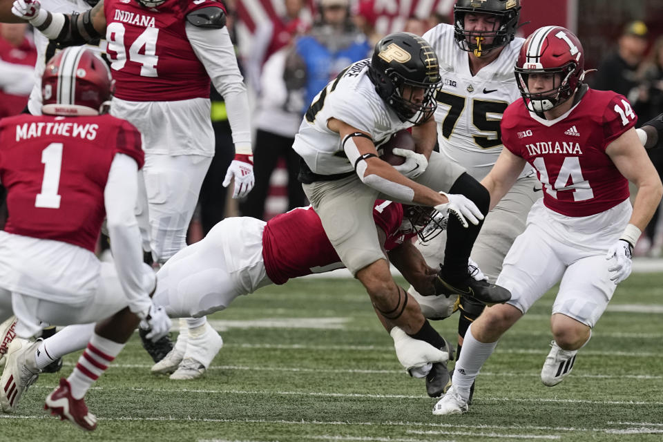 Purdue running back Devin Mockobee, center right, is tackled by Indiana's Jonathan Haynes during the first half of an NCAA college football game, Saturday, Nov. 26, 2022, in Bloomington, Ind. (AP Photo/Darron Cummings)