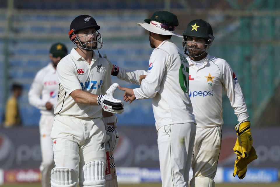 New Zealand's Kane Williamson, who scores 200 runs not out, is congratulated by Pakistan's Agha Salman, center, and Sarfraz Ahmed, right, during the fourth day of first test cricket match between Pakistan and New Zealand, in Karachi, Pakistan, Thursday, Dec. 29, 2022. (AP Photo/Fareed Khan)