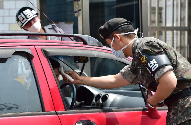 South Korean soldiers check the body heat of visitors at the entrance of the Defence Ministry in Seoul on June 9, 2015