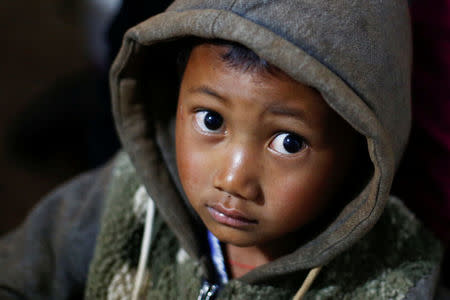 A refugee boy who fled with his family fighting in neighbouring Myanmar rests in the house of a relative in the village of Baiyan near Nansan in the Yunnan province, China, March 11, 2017. REUTERS/Thomas Peter