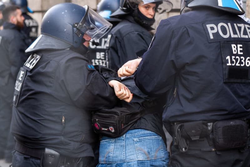 One of the pro-Palestinian occupiers of the Institute of Social Sciences at Berlin's Humboldt University (HU) is taken out of the building by police officers. Activists have occupied the university in support of the Palestinians and in protest against Israel. Christophe Gateau/dpa