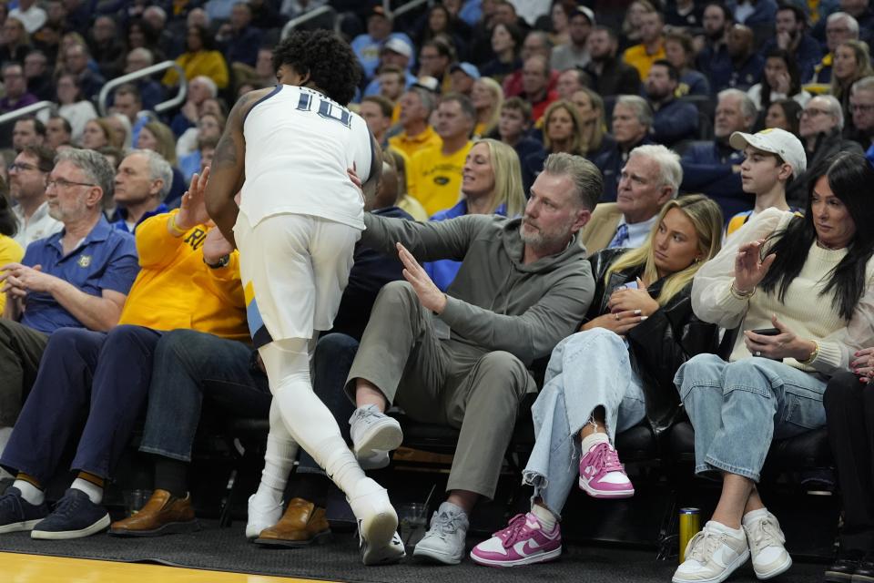 Marquette's Zaide Lowery runs into Chicago Bears head coach Matt Eberflus during the first half of an NCAA college basketball game against UConn Wednesday, March 6, 2024, in Milwaukee. (AP Photo/Morry Gash)