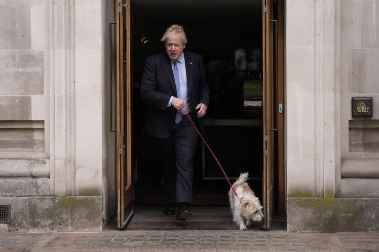 El primer ministro de Gran Bretaña, Boris Johnson, abandona un centro electoral acompañado por su perro Dilyn, en el centro de Londres, luego de votar en comicios locales, el 5 de mayo de 2022. (AP Foto/Matt Dunham)