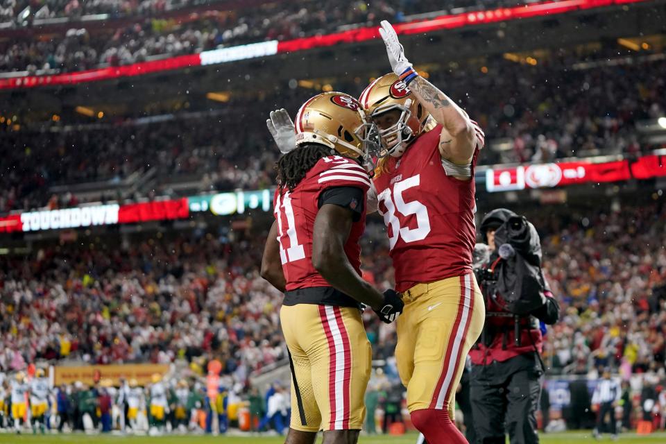 San Francisco 49ers tight end George Kittle (85) celebrates with wide receiver Brandon Aiyuk (11) after scoring a touchdown against the Green Bay Packers during the second quarter in a 2024 NFC divisional round game at Levi's Stadium.