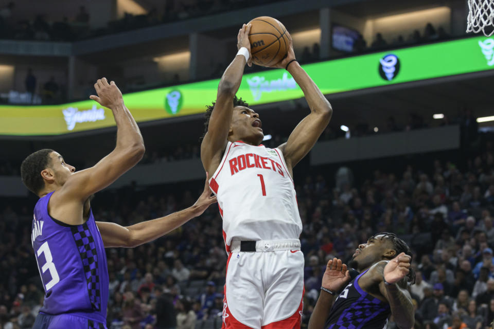 Houston Rockets forward Amen Thompson (1) shoots over Sacramento Kings forward Keegan Murray, left, and guard Davion Mitchell during the first half of an NBA basketball game in Sacramento, Calif., Sunday, March 10, 2024. (AP Photo/Randall Benton)