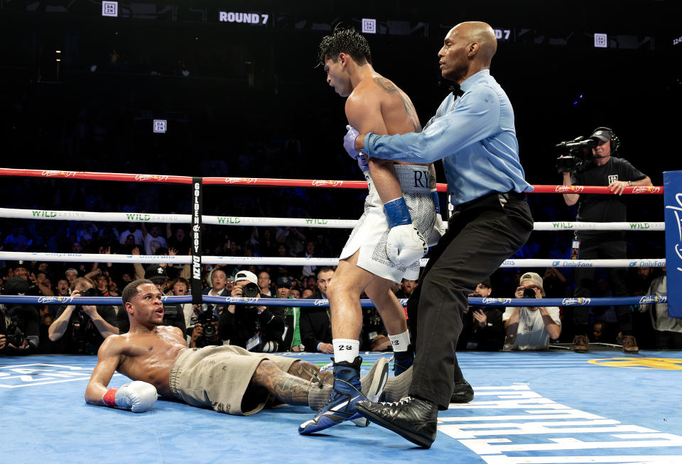 NEW YORK, NEW YORK - APRIL 20:   Ryan Garcia (white trunks) knocks down Devin Haney (gray trunks) during their WBC Super Lightweight title bout at Barclays Center on April 20, 2024 in New York City. (Photo by Al Bello/Getty Images)